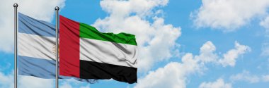 Arjantin ve Birleşik Arap Emirlikleri bayrağı birlikte beyaz bulutlu mavi gökyüzüne karşı rüzgarsal sallayarak. Diplomasi kavramı, uluslararası ilişkiler.