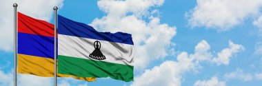 Ermenistan ve Lesotho bayrağı birlikte beyaz bulutlu mavi gökyüzüne karşı rüzgarda sallayarak. Diplomasi kavramı, uluslararası ilişkiler.