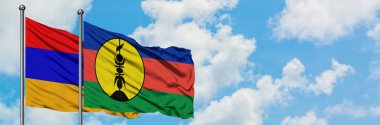 Ermenistan ve Yeni Kaledonya bayrağı birlikte beyaz bulutlu mavi gökyüzüne karşı rüzgarda sallayarak. Diplomasi kavramı, uluslararası ilişkiler.