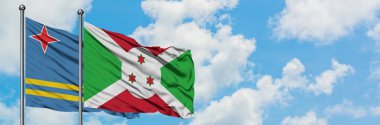 Aruba ve Burundi bayrağı birlikte beyaz bulutlu mavi gökyüzüne karşı rüzgarda sallayarak. Diplomasi kavramı, uluslararası ilişkiler.