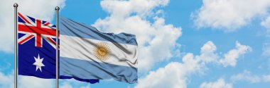 Avustralya ve Arjantin bayrağı birlikte beyaz bulutlu mavi gökyüzüne karşı rüzgarda sallayarak. Diplomasi kavramı, uluslararası ilişkiler.