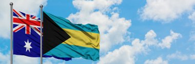 Avustralya ve Bahamalar bayrağı birlikte beyaz bulutlu mavi gökyüzüne karşı rüzgarda sallayarak. Diplomasi kavramı, uluslararası ilişkiler.