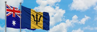 Avustralya ve Barbados bayrağı birlikte beyaz bulutlu mavi gökyüzüne karşı rüzgarda sallayarak. Diplomasi kavramı, uluslararası ilişkiler.