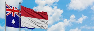 Avustralya ve Endonezya bayrağı birlikte beyaz bulutlu mavi gökyüzüne karşı rüzgarsal sallayarak. Diplomasi kavramı, uluslararası ilişkiler.