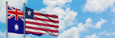 Avustralya ve Liberya bayrağı birlikte beyaz bulutlu mavi gökyüzüne karşı rüzgarda sallayarak. Diplomasi kavramı, uluslararası ilişkiler.