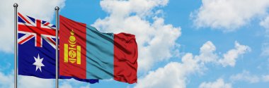 Avustralya ve Moğolistan bayrağı birlikte beyaz bulutlu mavi gökyüzüne karşı rüzgarda sallayarak. Diplomasi kavramı, uluslararası ilişkiler.