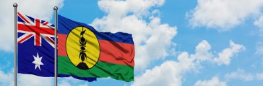 Avustralya ve Yeni Kaledonya bayrağı birlikte beyaz bulutlu mavi gökyüzüne karşı rüzgarda sallayarak. Diplomasi kavramı, uluslararası ilişkiler.