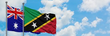 Avustralya ve Saint Kitts ve Nevis bayrağı birlikte beyaz bulutlu mavi gökyüzüne karşı rüzgarda sallayarak. Diplomasi kavramı, uluslararası ilişkiler.