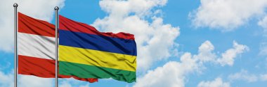 Avusturya ve Mauritius bayrağı birlikte beyaz bulutlu mavi gökyüzüne karşı rüzgarda sallayarak. Diplomasi kavramı, uluslararası ilişkiler.
