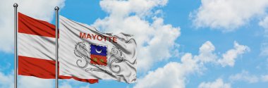 Avusturya ve Mayotte bayrağı birlikte beyaz bulutlu mavi gökyüzüne karşı rüzgarda sallayarak. Diplomasi kavramı, uluslararası ilişkiler.