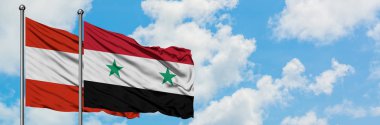 Avusturya ve Suriye bayrağı birlikte beyaz bulutlu mavi gökyüzüne karşı rüzgarsal sallayarak. Diplomasi kavramı, uluslararası ilişkiler.