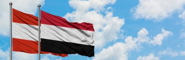 Avusturya ve Yemen bayrağı birlikte beyaz bulutlu mavi gökyüzüne karşı rüzgarsal sallayarak. Diplomasi kavramı, uluslararası ilişkiler.