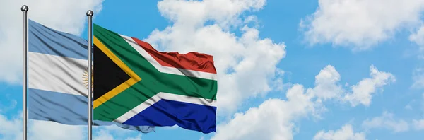 Vlajka Argentiny a Jihoafrické republiky mávajících větrem proti bílé zatažené modré obloze. Diplomacie, mezinárodní vztahy. — Stock fotografie