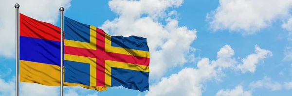 亚美尼亚和阿兰群岛国旗在风中飘扬，白云蓝天相聚。外交概念、国际关系. — 图库照片