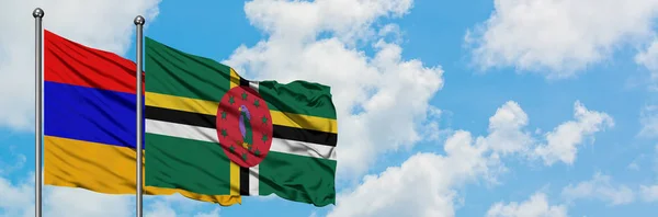 Armênia e Dominica bandeira acenando no vento contra o céu azul nublado branco juntos. Conceito de diplomacia, relações internacionais . — Fotografia de Stock