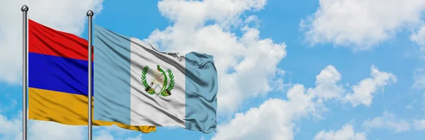 Armenia e Guatemala sventolano insieme la bandiera contro il bianco cielo azzurro nuvoloso. Concetto di diplomazia, relazioni internazionali . — Foto Stock