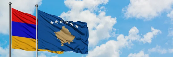 Bandera de Armenia y Kosovo ondeando en el viento contra el cielo azul nublado blanco juntos. Concepto diplomático, relaciones internacionales . — Foto de Stock