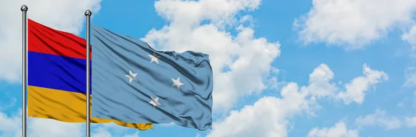 Bandera de Armenia y Micronesia ondeando en el viento contra el cielo azul nublado blanco juntos. Concepto diplomático, relaciones internacionales . — Foto de Stock