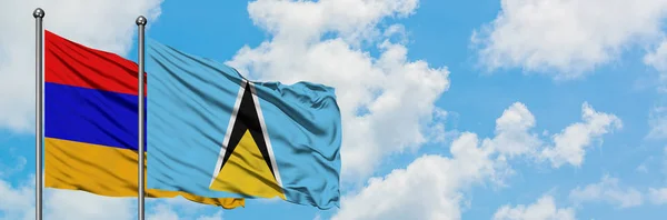 Armenien och Saint Lucia flagga vifta i vinden mot vit grumlig blå himmel tillsammans. Diplomatisk koncept, internationella relationer. — Stockfoto