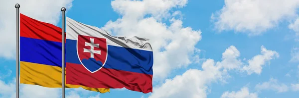 Drapeau de l'Arménie et de la Slovaquie agitant dans le vent contre le ciel bleu nuageux blanc ensemble. Concept de diplomatie, relations internationales . — Photo