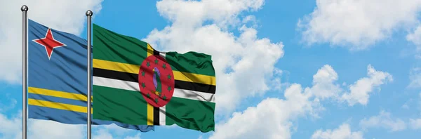 阿鲁巴和多米尼加国旗在风中飘扬，与白云相间的蓝天相一起。外交概念、国际关系. — 图库照片