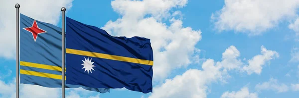 아루바와 나우루 깃발이 하얀 흐린 푸른 하늘을 배경으로 바람에 흔들리고 있습니다. 외교 개념, 국제 관계. — 스톡 사진