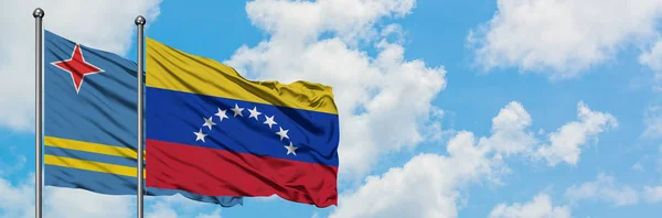 Аруба і Венесуела прапор розмахуючи в вітру проти білого хмарного синього неба разом. Концепція дипломатії, міжнародні відносини. — стокове фото