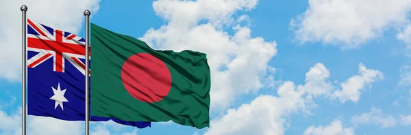Bandera de Australia y Bangladesh ondeando en el viento contra el cielo azul nublado blanco juntos. Concepto diplomático, relaciones internacionales . — Foto de Stock