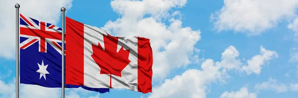 Bandera de Australia y Canadá ondeando en el viento contra el cielo azul nublado blanco juntos. Concepto diplomático, relaciones internacionales . — Foto de Stock