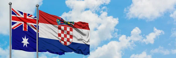 Bandera de Australia y Croacia ondeando en el viento contra el cielo azul nublado blanco juntos. Concepto diplomático, relaciones internacionales . — Foto de Stock
