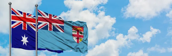 澳大利亚和斐济国旗在风中飘扬，共同面对白云蓝天。外交概念、国际关系. — 图库照片