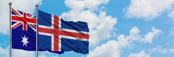 Bandera de Australia e Islandia ondeando en el viento contra el cielo azul nublado blanco juntos. Concepto diplomático, relaciones internacionales . — Foto de Stock