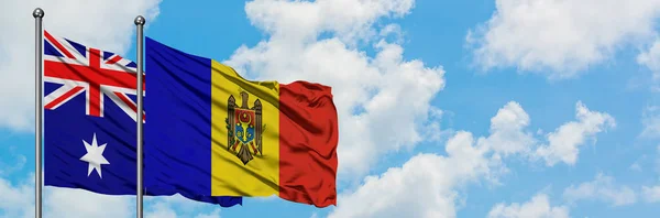 Bandera de Australia y Moldavia ondeando en el viento contra el cielo azul nublado blanco juntos. Concepto diplomático, relaciones internacionales . — Foto de Stock