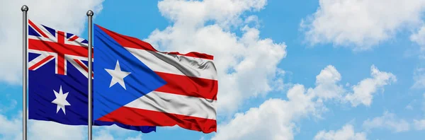 澳大利亚和波多黎各国旗在风中飘扬，共同面对白云蓝天。外交概念、国际关系. — 图库照片