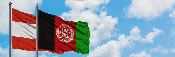 Bandera de Austria y Afganistán ondeando en el viento contra el cielo azul nublado blanco juntos. Concepto diplomático, relaciones internacionales . — Foto de Stock