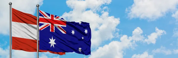 Bandera de Austria y Australia ondeando en el viento contra el cielo azul nublado blanco juntos. Concepto diplomático, relaciones internacionales . — Foto de Stock