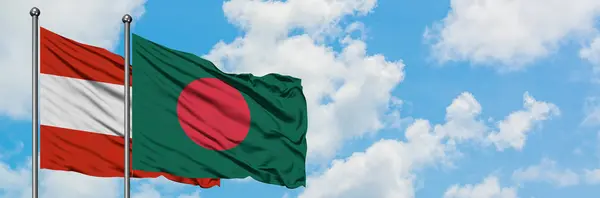 Bandera de Austria y Bangladesh ondeando en el viento contra el cielo azul nublado blanco juntos. Concepto diplomático, relaciones internacionales . — Foto de Stock