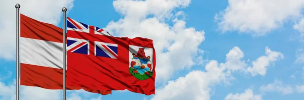 Bandera de Austria y Bermudas ondeando en el viento contra el cielo azul nublado blanco juntos. Concepto diplomático, relaciones internacionales . — Foto de Stock