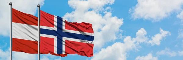 Bandera de Austria y Bouvet Islands ondeando en el viento contra el cielo azul nublado blanco juntos. Concepto diplomático, relaciones internacionales . — Foto de Stock