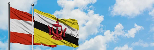 Oostenrijk en Brunei vlag zwaaien in de wind tegen witte bewolkte blauwe hemel samen. Diplomatie concept, internationale betrekkingen. — Stockfoto