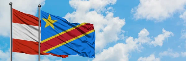 Bandera de Austria y Congo ondeando en el viento contra el cielo azul nublado blanco juntos. Concepto diplomático, relaciones internacionales . — Foto de Stock