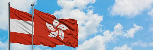 Avusturya ve Hong Kong bayrağı birlikte beyaz bulutlu mavi gökyüzüne karşı rüzgarda sallayarak. Diplomasi kavramı, uluslararası ilişkiler. — Stok fotoğraf