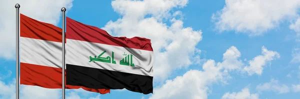 Austria and Iraq flag waving in the wind against white cloudy blue sky together. Diplomacy concept, international relations.