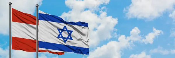 A bandeira da Áustria e de Israel agitando no vento contra o céu azul nublado branco juntos. Conceito de diplomacia, relações internacionais . — Fotografia de Stock