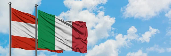 Bandera de Austria e Italia ondeando en el viento contra el cielo azul nublado blanco juntos. Concepto diplomático, relaciones internacionales . — Foto de Stock