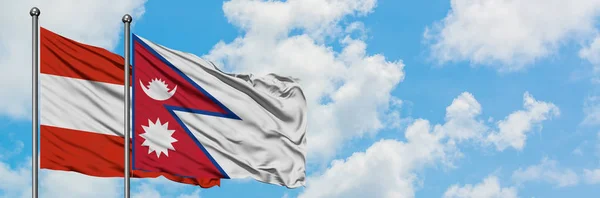 Avusturya ve Nepal bayrağı birlikte beyaz bulutlu mavi gökyüzüne karşı rüzgarda sallayarak. Diplomasi kavramı, uluslararası ilişkiler. — Stok fotoğraf