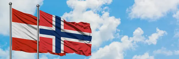 Bandera de Austria y Noruega ondeando en el viento contra el cielo azul nublado blanco juntos. Concepto diplomático, relaciones internacionales . — Foto de Stock