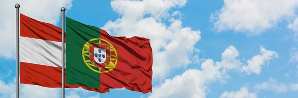 Bandera de Austria y Portugal ondeando en el viento contra el cielo azul nublado blanco juntos. Concepto diplomático, relaciones internacionales . — Foto de Stock