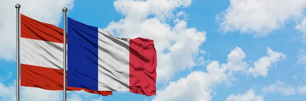Austria i Reunion flaga machając w wiatr przed białym zachmurzone błękitne niebo razem. Koncepcja dyplomacji, stosunki międzynarodowe. — Zdjęcie stockowe