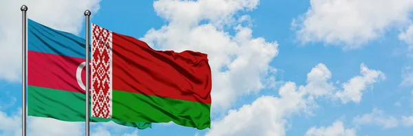 Bandera de Azerbaiyán y Bielorrusia ondeando en el viento contra el cielo azul nublado blanco juntos. Concepto diplomático, relaciones internacionales . — Foto de Stock